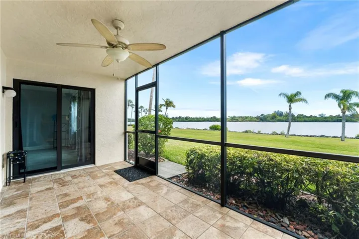 Unfurnished sunroom featuring a water view and ceiling fan
