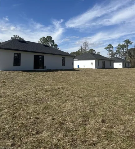 Rear view of house featuring a lawn