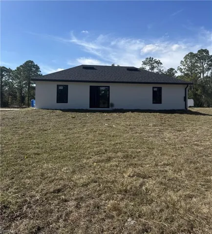 Rear view of house with a lawn
