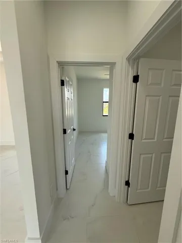 Corridor with marble finish floor and baseboards