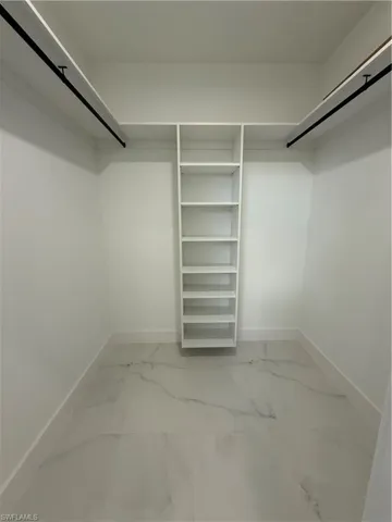 Walk in closet with marble finish floor