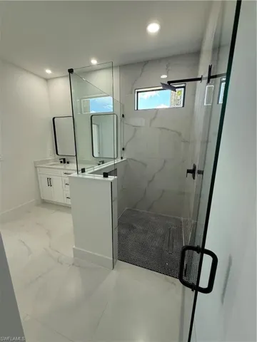 Full bathroom with a marble finish shower, recessed lighting, marble finish floor, and vanity