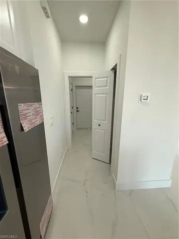 Corridor with recessed lighting, visible vents, marble finish floor, and baseboards