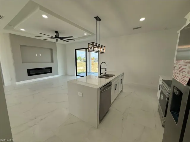 Kitchen with recessed lighting, visible vents, stainless steel appliances, marble finish floor, and a sink