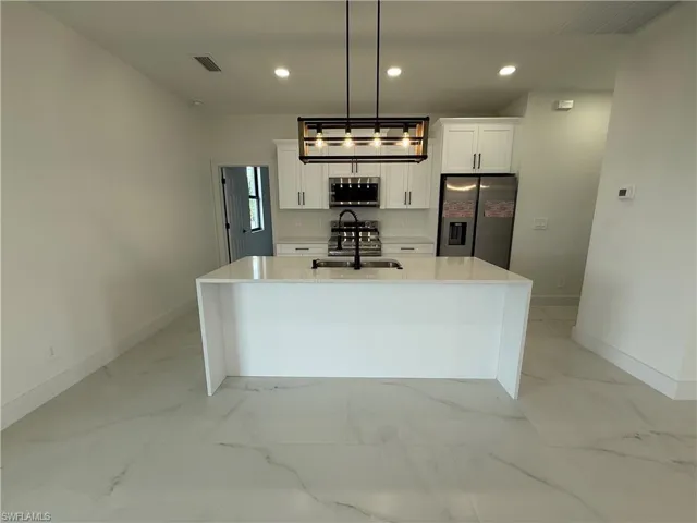 Kitchen featuring visible vents, white cabinetry, recessed lighting, stainless steel appliances, and marble finish floor