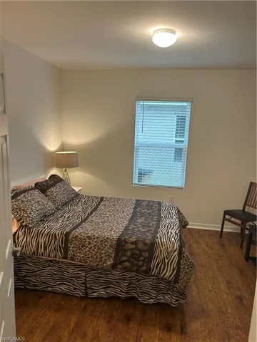 Bedroom featuring dark wood-type flooring and baseboards