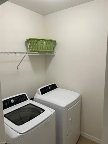 Laundry area with washing machine and dryer and baseboards