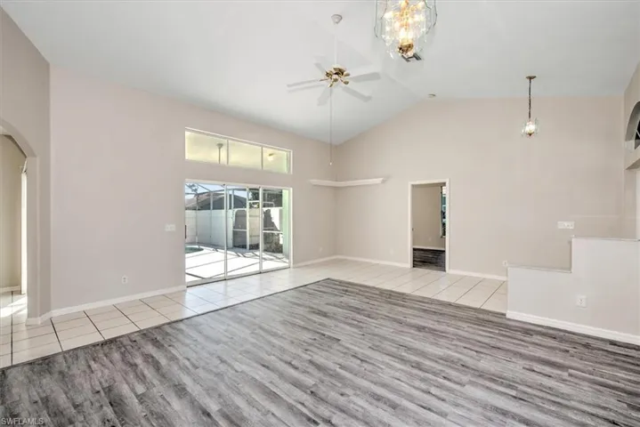 Unfurnished living room with light wood-type flooring, high vaulted ceiling, and ceiling fan