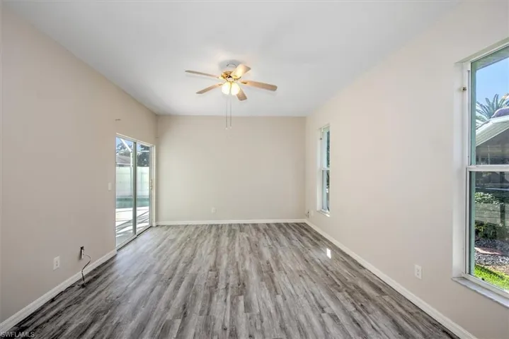 Unfurnished room with hardwood / wood-style floors, ceiling fan, and a healthy amount of sunlight
