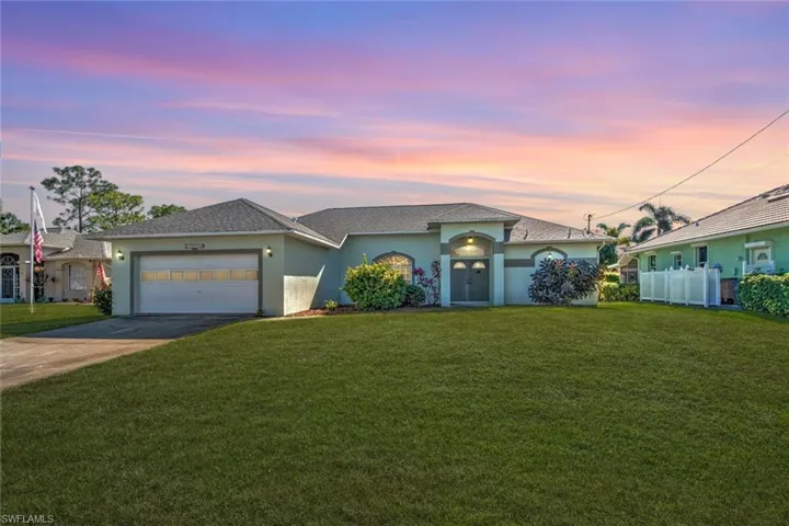 View of front of house with a lawn and a garage