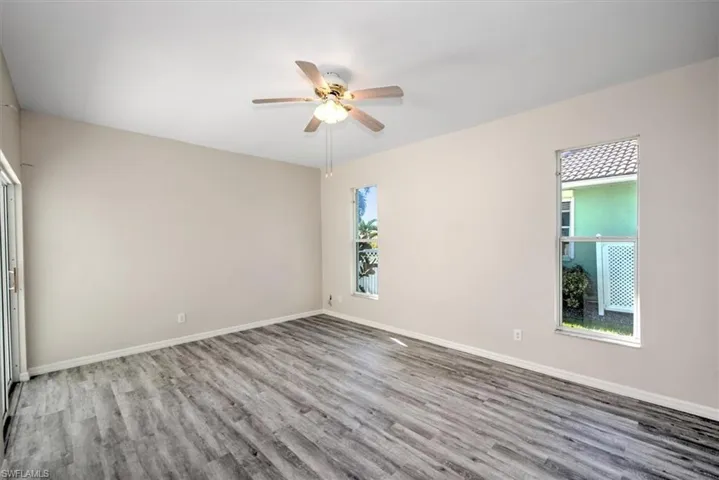 Spare room featuring light hardwood / wood-style floors, ceiling fan, and a healthy amount of sunlight