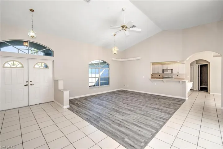 Tiled entrance foyer with high vaulted ceiling and ceiling fan