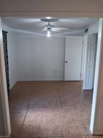 Spare room with a ceiling fan and tile patterned floors