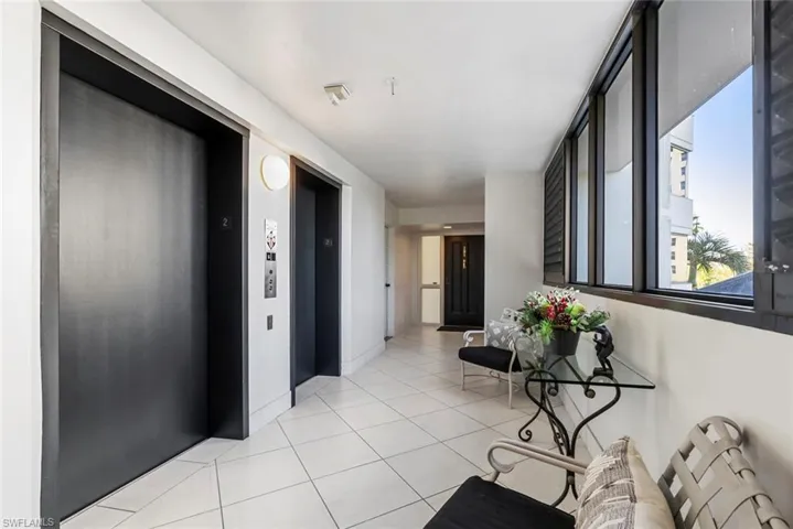 Hall featuring elevator and light tile patterned floors