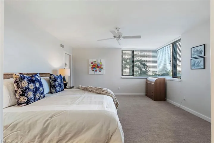 Bedroom with ceiling fan and light colored carpet