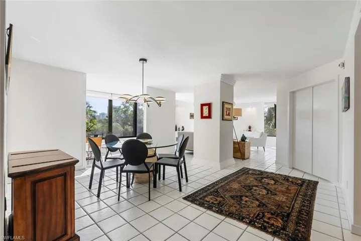 Tiled dining room featuring an inviting chandelier