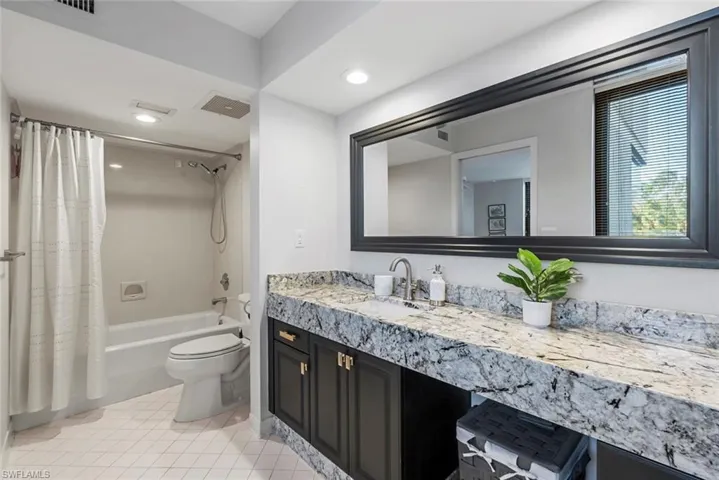Full bathroom with tile patterned floors, vanity, toilet, and shower / tub combo