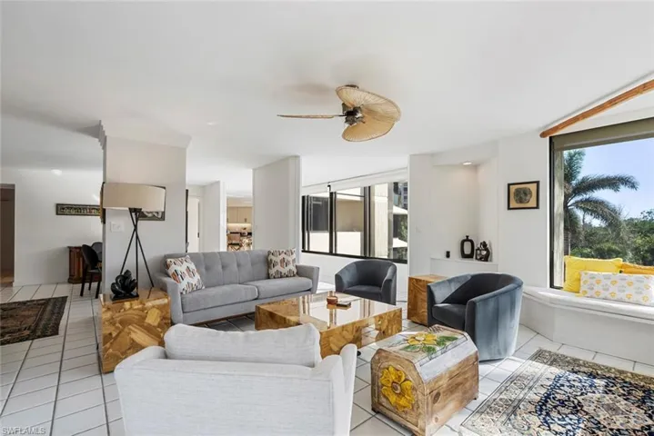 Tiled living room with plenty of natural light and ceiling fan