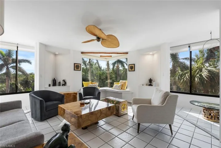 Living room with ceiling fan, plenty of natural light, and light tile patterned floors