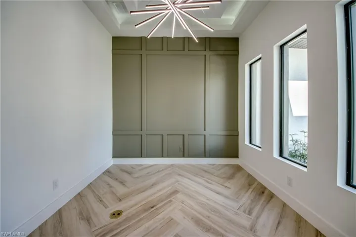 Empty room featuring a decorative wall and parquet floors
