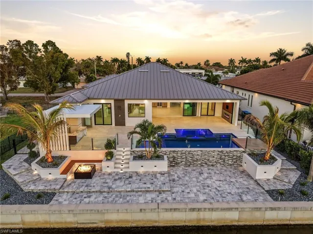 Back of house with a patio area, a jacuzzi, a fenced backyard, an outdoor pool, and a fire pit