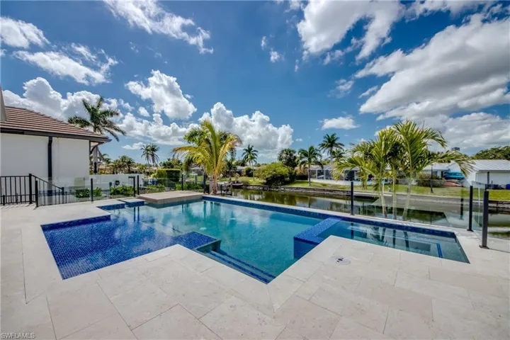 Integrated pool / hot tub featuring a patio and a water view