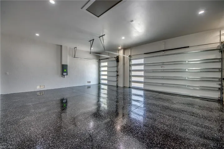 Garage with a textured wall and recessed lighting