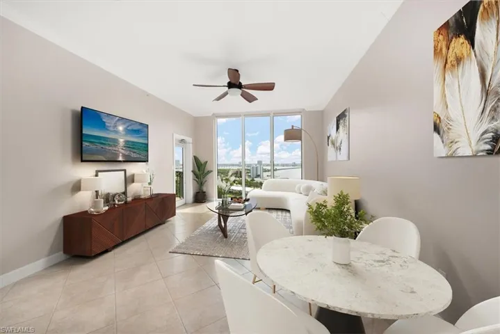 Living area featuring expansive windows, a ceiling fan, light tile patterned floors, and crown molding