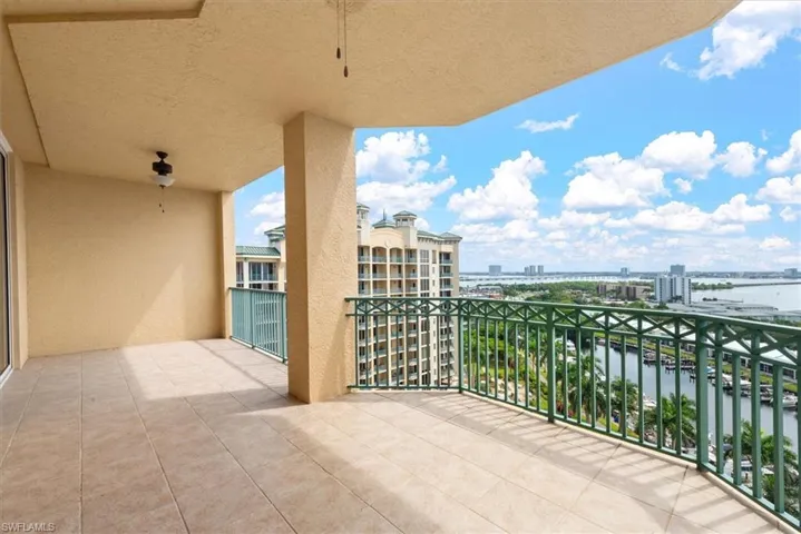 Balcony featuring a water view, a city view, and a sunroom