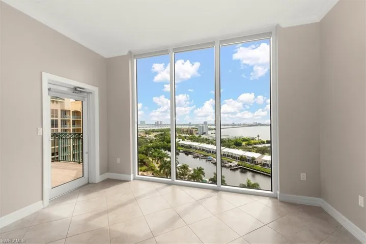 Unfurnished room featuring crown molding, a water view, light tile patterned floors, and floor to ceiling windows