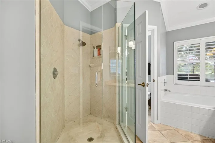 Bathroom with a shower stall, ornamental molding, a bath, and tile patterned flooring