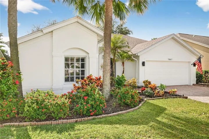 View of front of house with stucco siding, decorative driveway, a front lawn, and a garage