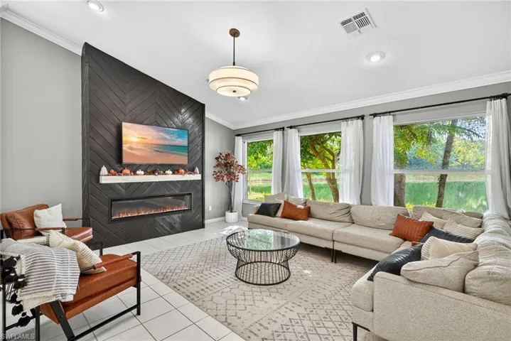 Tiled living area with ornamental molding and a large fireplace