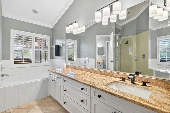 Bathroom featuring ornamental molding, a stall shower, vanity, light tile patterned floors, and a garden tub