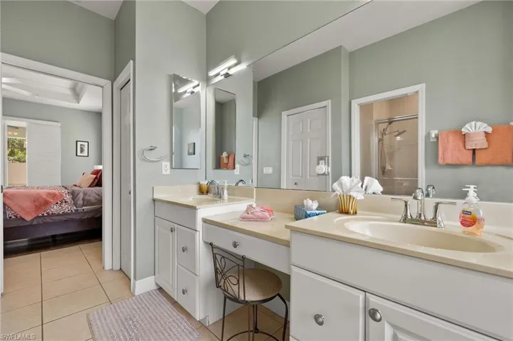 Bathroom featuring tile patterned floors, vanity, ornamental molding, and walk in shower