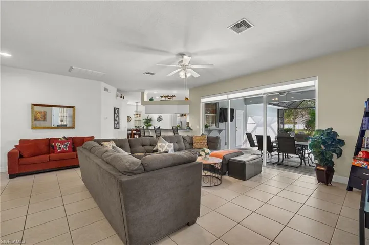 Tiled living room with ceiling fan and a textured ceiling