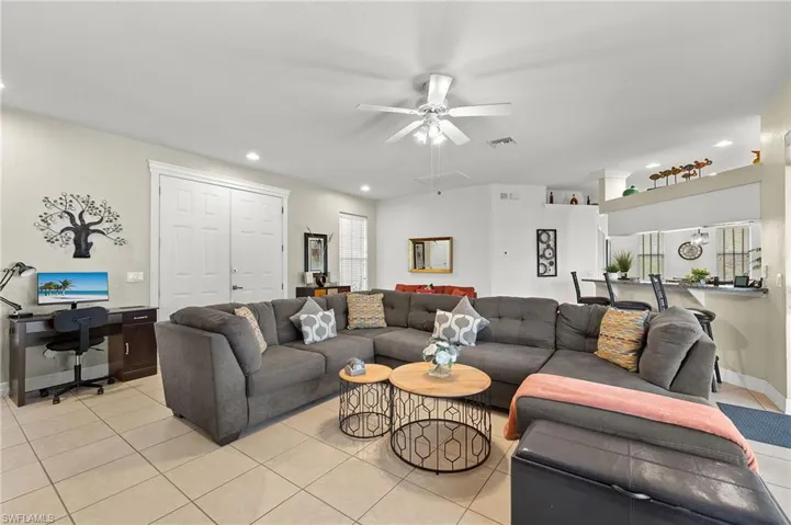 Living room with light tile patterned floors and ceiling fan