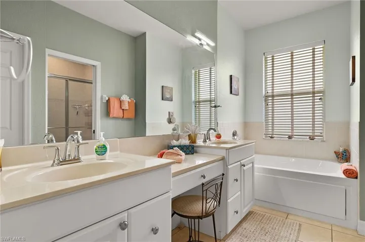 Bathroom with tile patterned flooring, vanity, and independent shower and bath