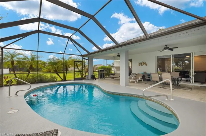 View of pool featuring a lanai, a patio area, ceiling fan, and grilling area