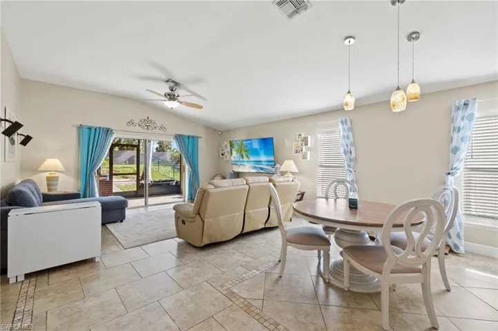 Tiled dining area featuring ceiling fan and lofted ceiling