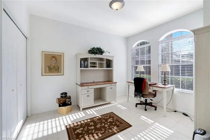 Office area featuring light tile patterned floors and baseboards