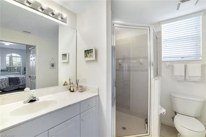 Ensuite bathroom with vanity, a stall shower, and light tile patterned floors