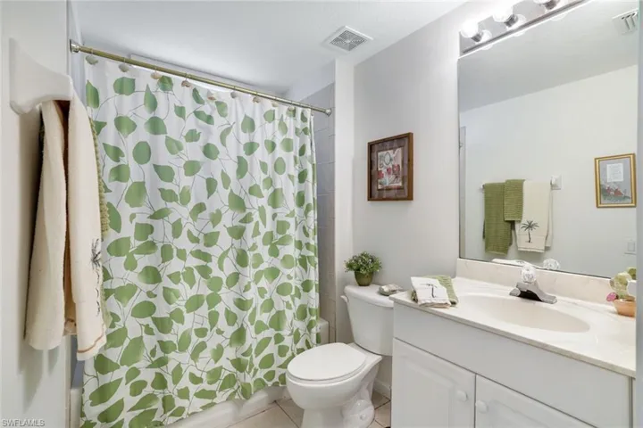 Full bath featuring vanity, light tile patterned flooring, and shower / bath combination with curtain