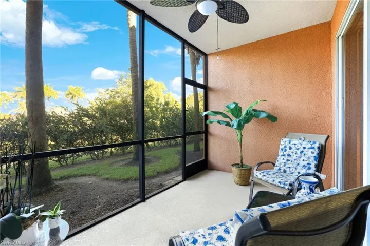 Unfurnished sunroom featuring a ceiling fan and view of wooded area