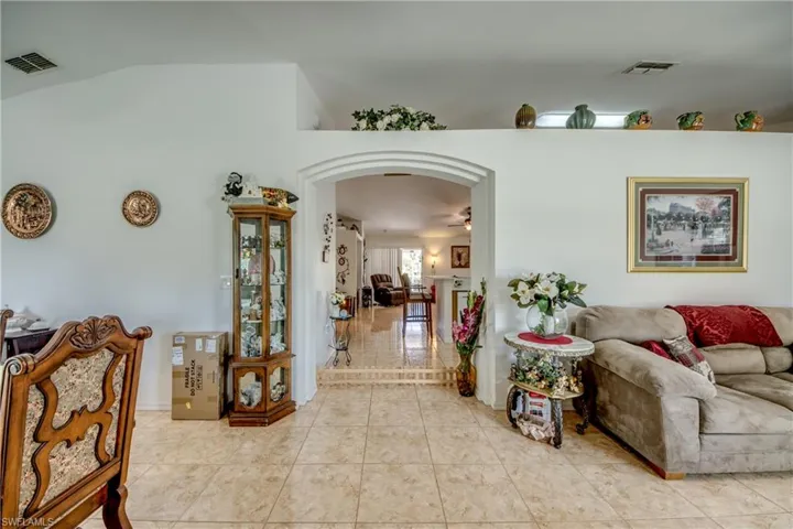 Living room featuring light tile patterned floors and lofted ceiling