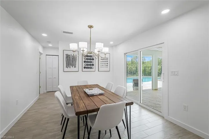 Dining room with light wood-style floors, a chandelier, and recessed lighting