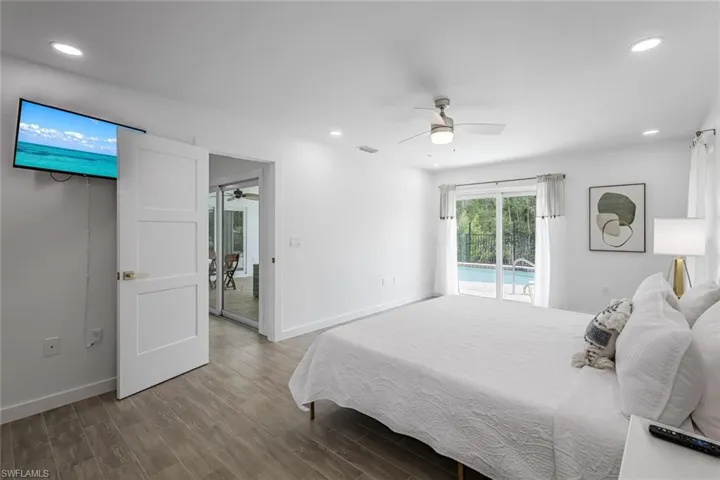 Bedroom with recessed lighting, wood finished floors, access to exterior, and ceiling fan