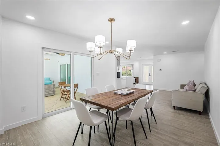 Dining area featuring recessed lighting, wood tiled floors, a chandelier, and ceiling fan
