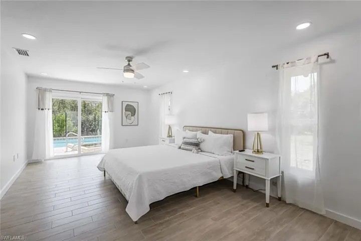 Bedroom with access to outside, wood finish floors, ceiling fan, and recessed lighting