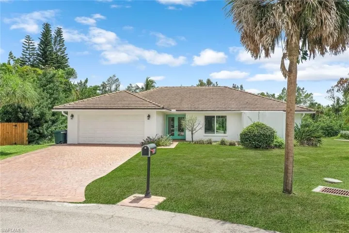 Single story home featuring decorative driveway, a front lawn, stucco siding, and an attached garage